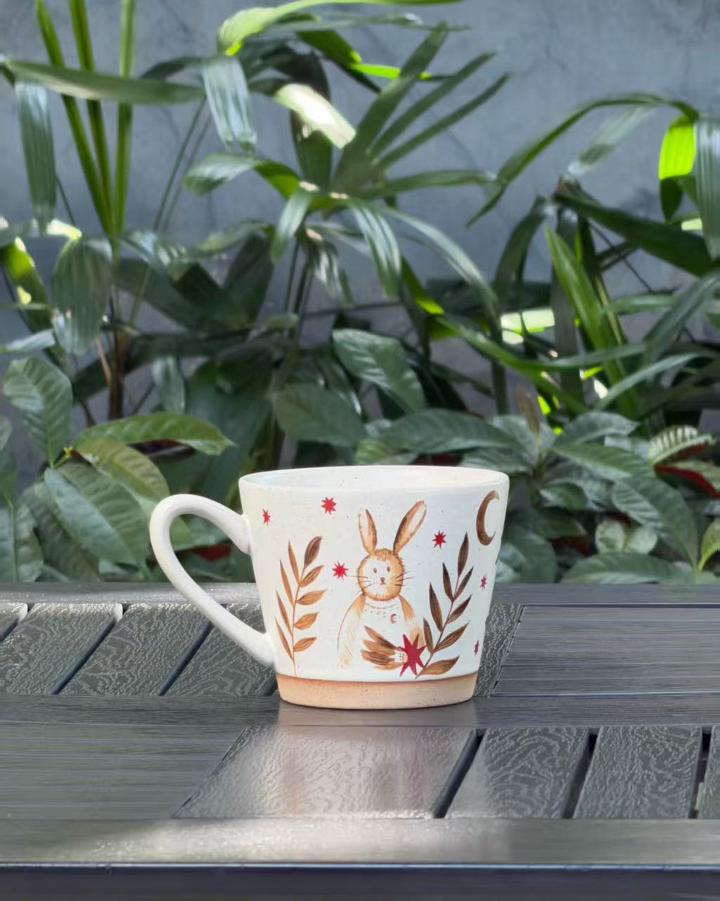 Back view of the Moonlit Rabbit ceramic mug with rabbit, crescent moon, stars and botanical motifs