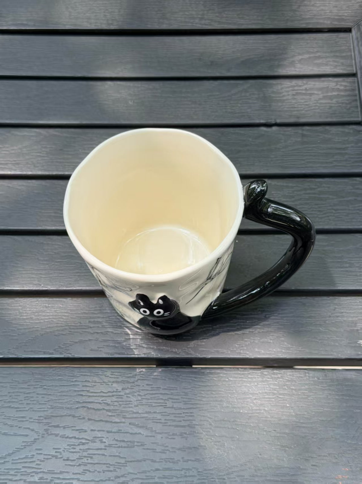Overhead view of the mug showing its light-colored glazed interior and softly uneven rim