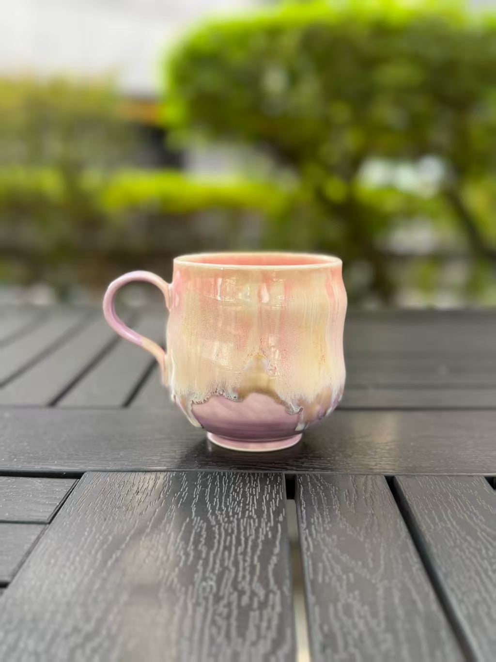 Angled back view of the mug showing the lavender base and irregular edge of its flowing glaze.