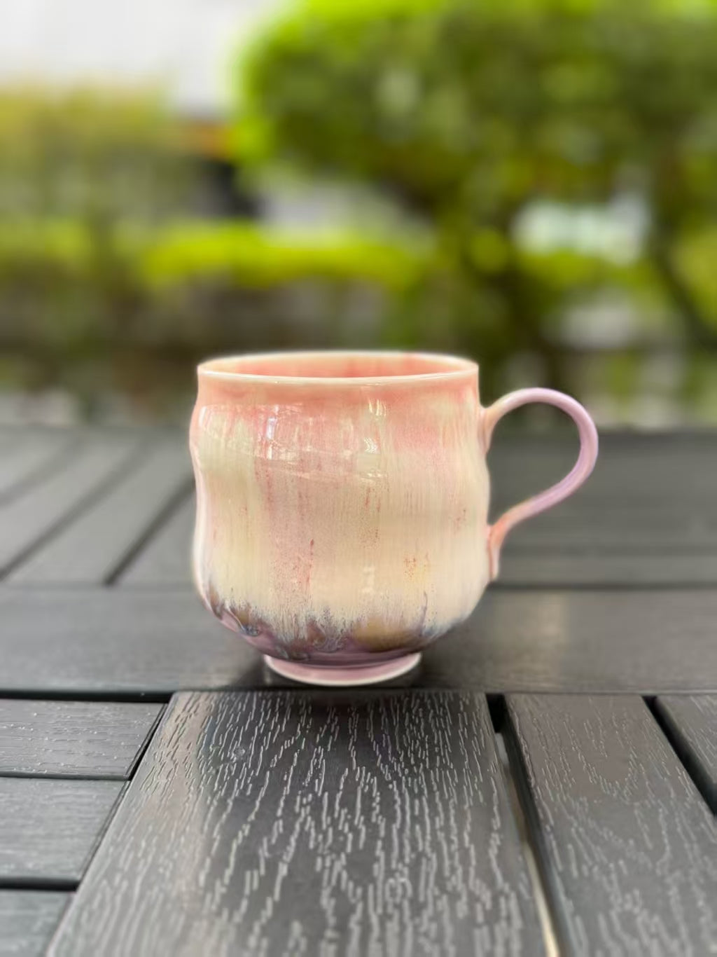 Pink and lavender kiln-glazed ceramic mug with a curved handle, showing soft color transitions across the front.