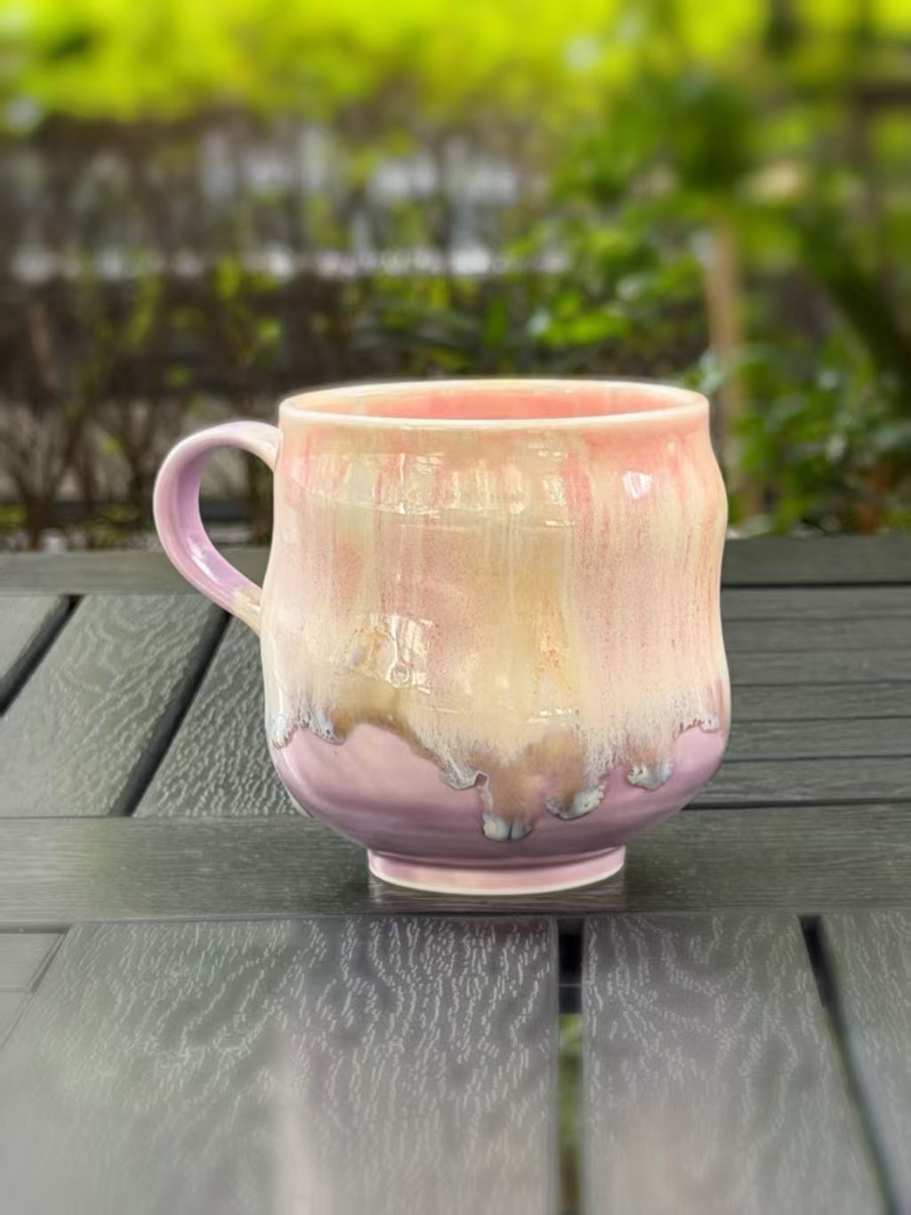 Ceramic mug with its handle on the left, showing cream glaze flowing over a lavender base.