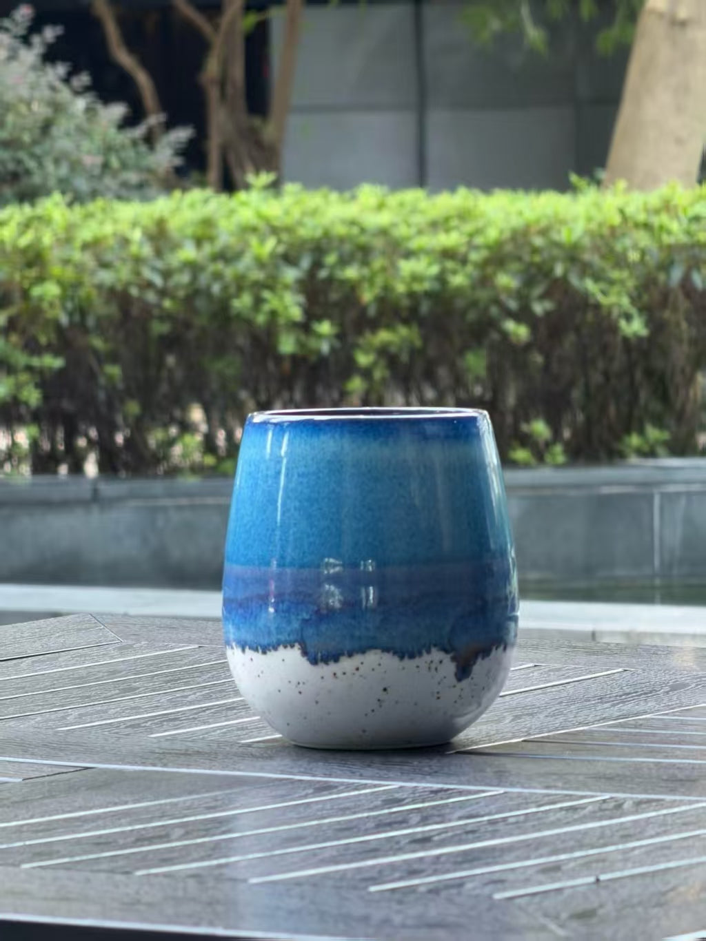 Side view of Coastal Tide ceramic mug showing the rounded form and layered ocean blue, violet and speckled cream reactive glaze