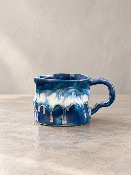 Cobalt blue kiln change mug with creamy white glaze flowing down the front and a blue handle