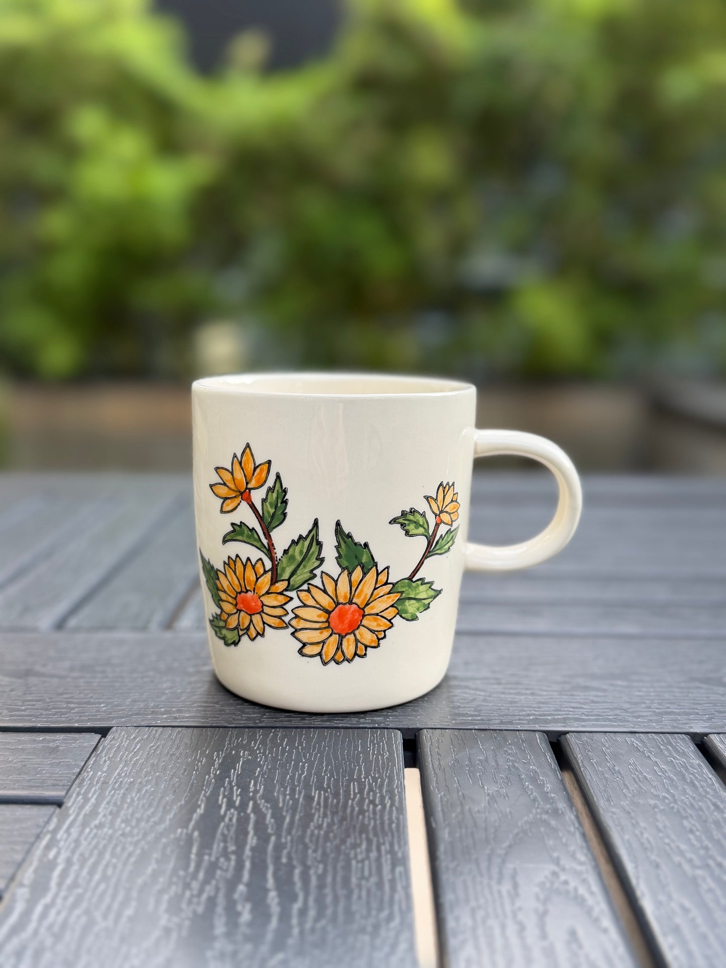 Hand-painted golden chrysanthemum ceramic mug, front view, white glaze with yellow flowers and green leaves