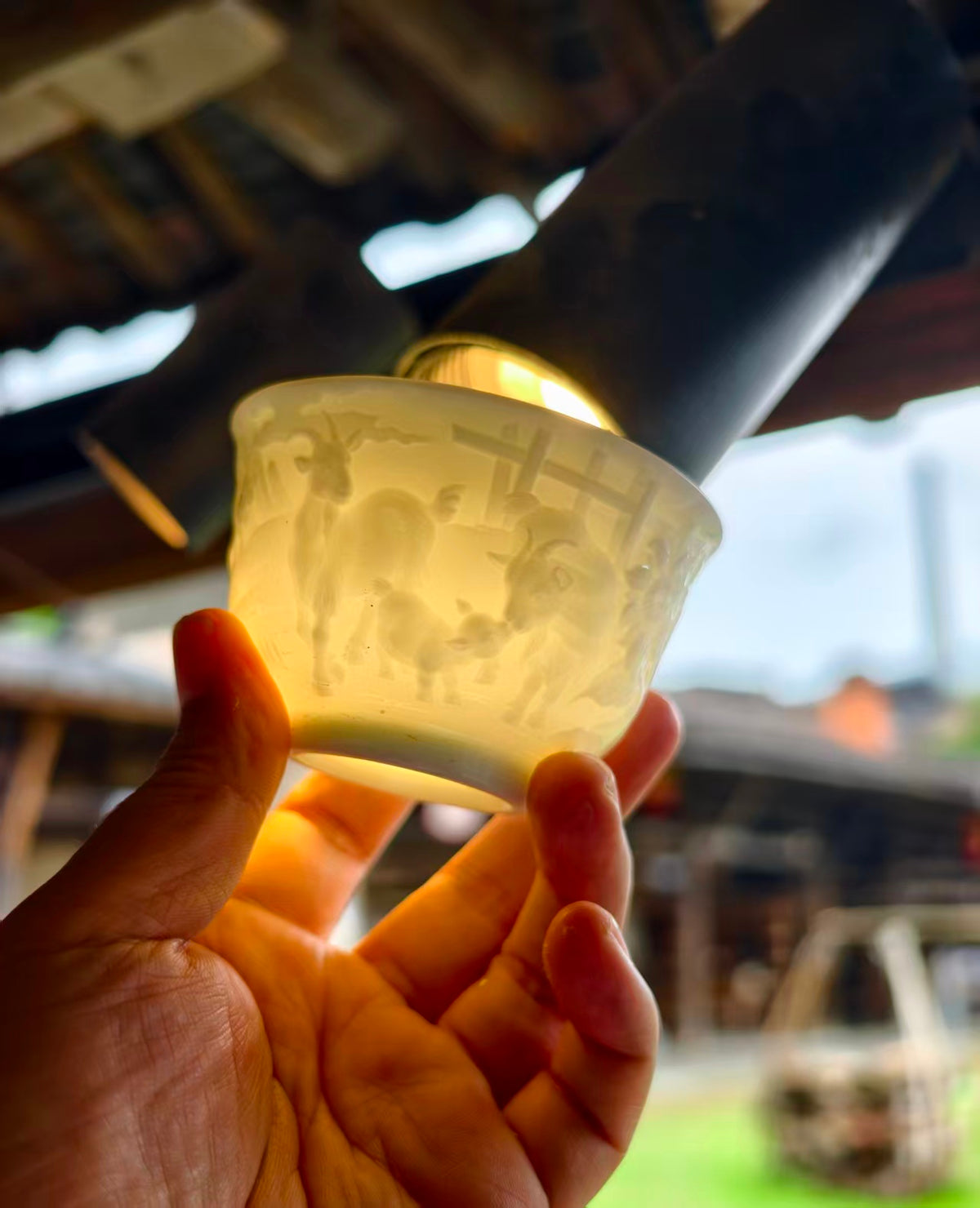 Hand-carved Goat Chinese Zodiac porcelain tea cup by Yan Wenlu illuminated to reveal the carving