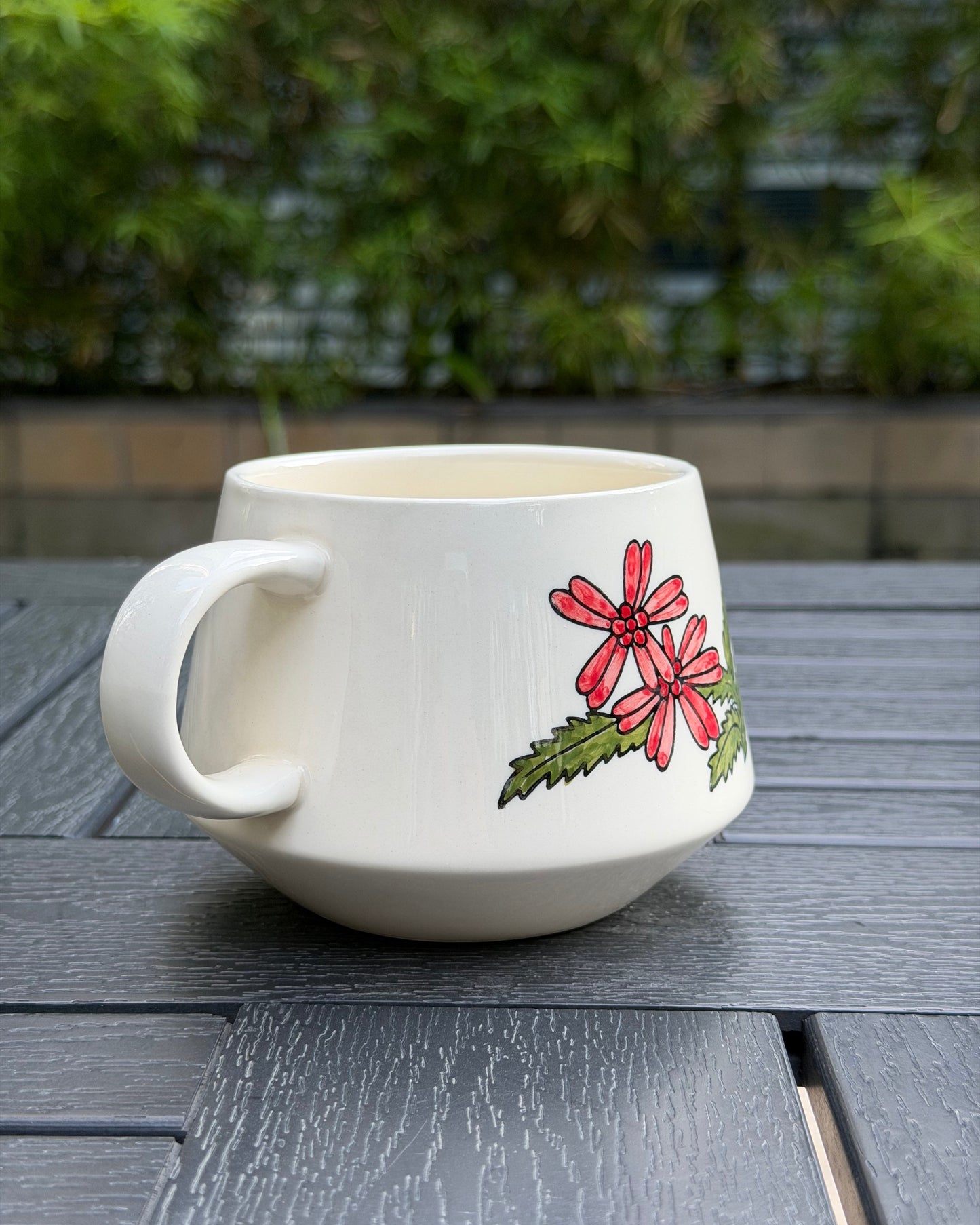 Side view of Meadow Cow ceramic mug showcasing the floral hand-painted underglaze design