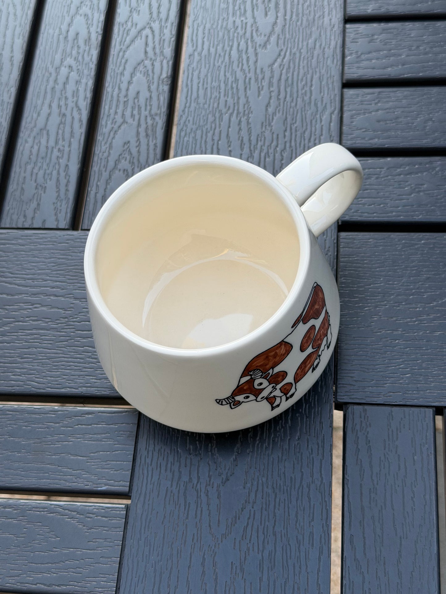 Top-down view of Meadow Cow ceramic mug showing the wide rim and cream glaze interior