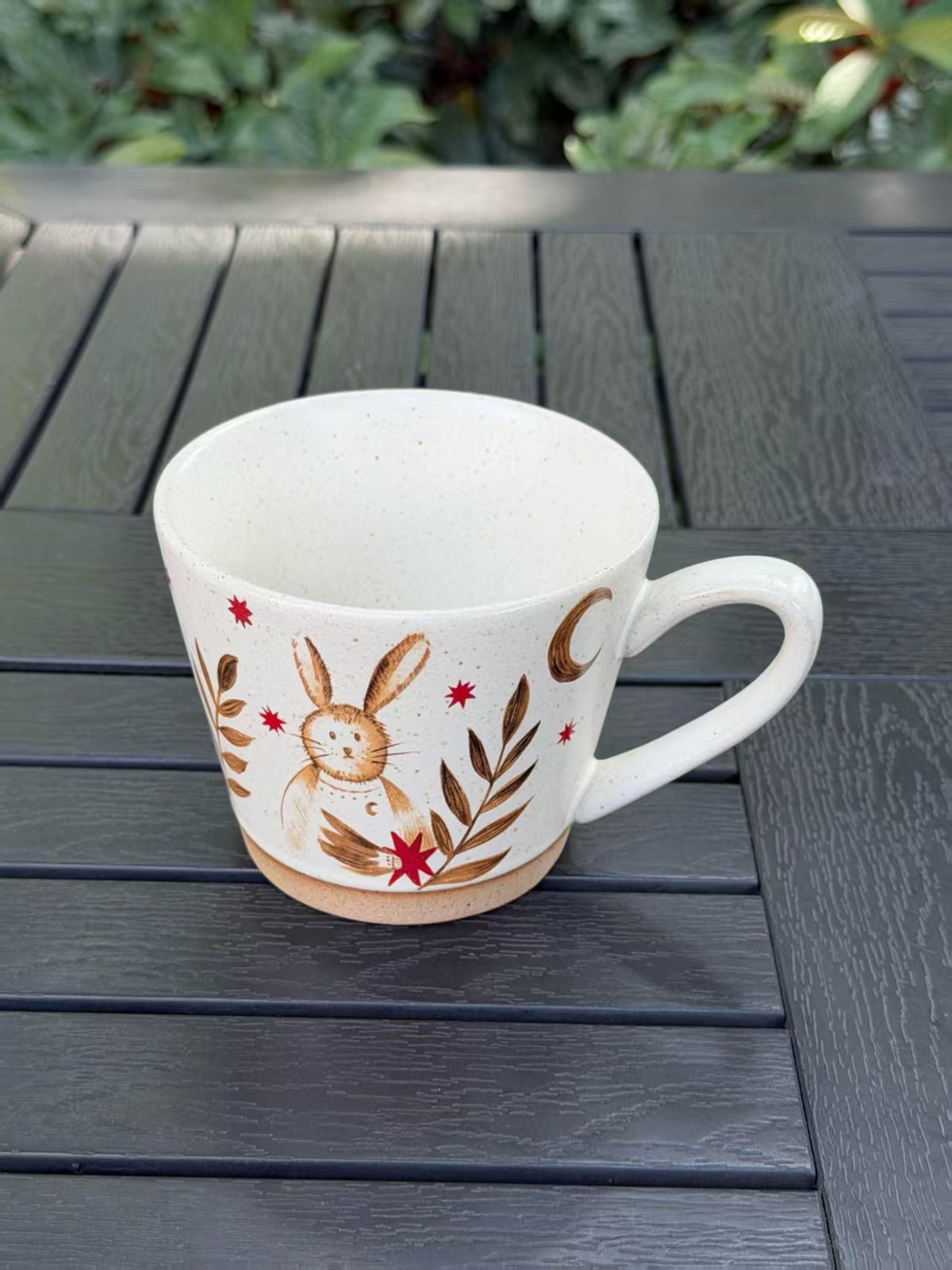 Moonlit Rabbit ceramic mug showing its warm speckled interior, rabbit design and curved handle