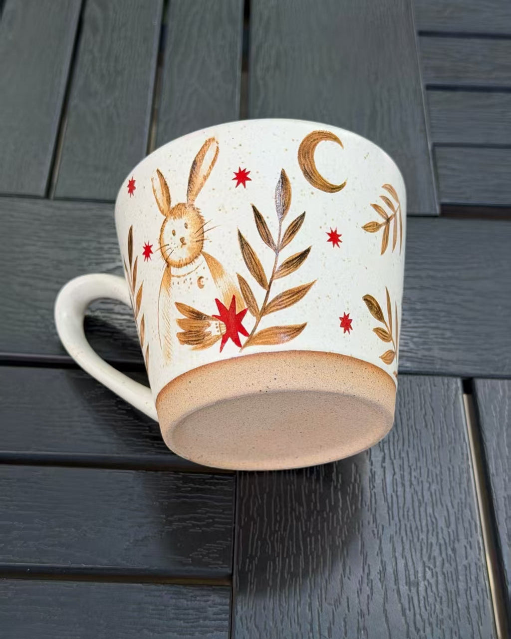 Moonlit Rabbit ceramic mug showing its warm speckled glaze, crescent moon design and natural unglazed base