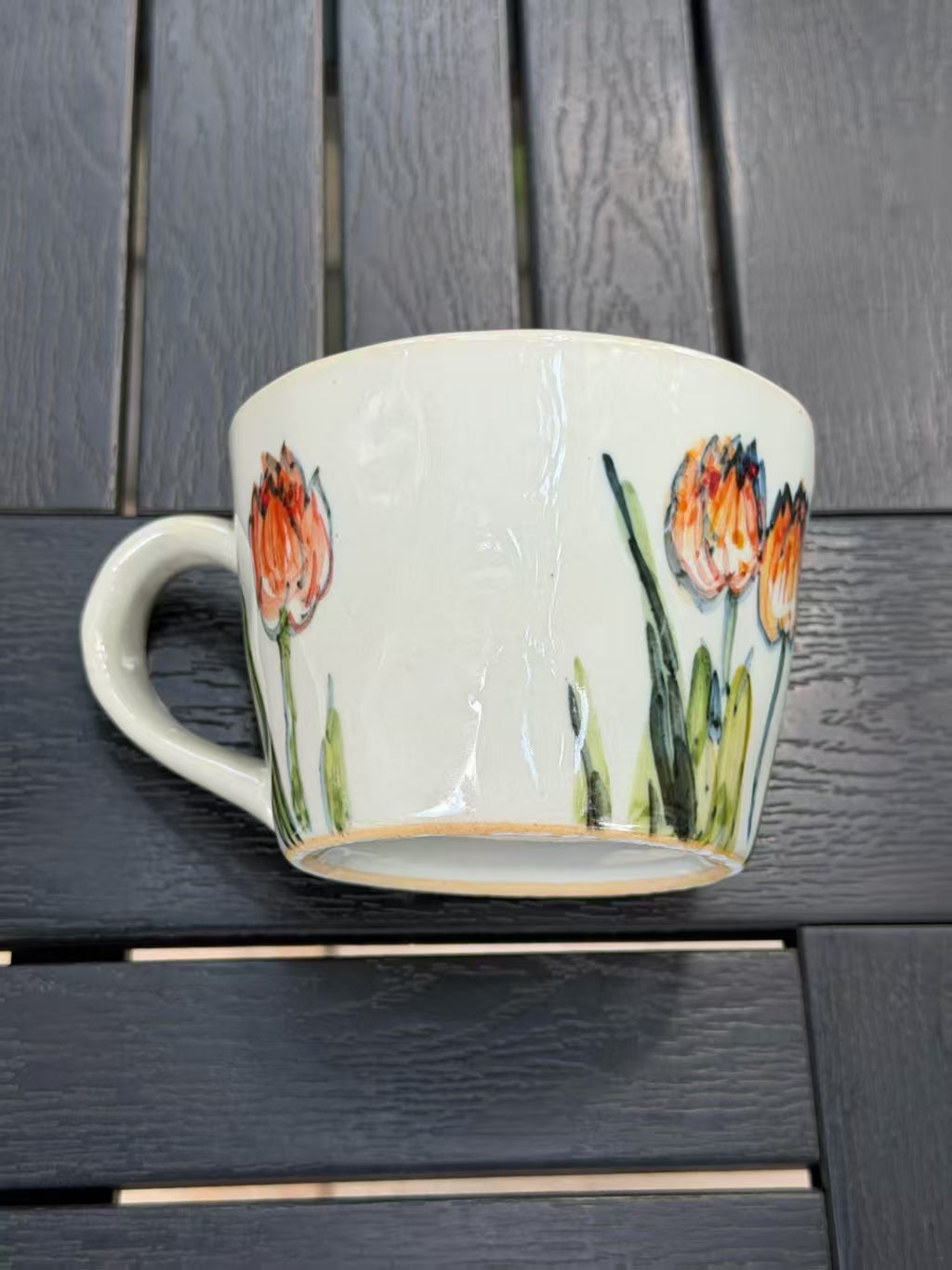 Orange Tulip hand-painted stoneware mug with freehand flowers wrapping around the ceramic form