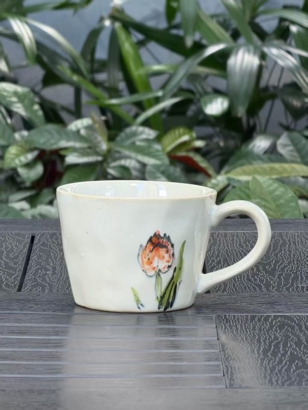 Hand-painted orange tulip mug showing natural variations in floral composition and brushwork