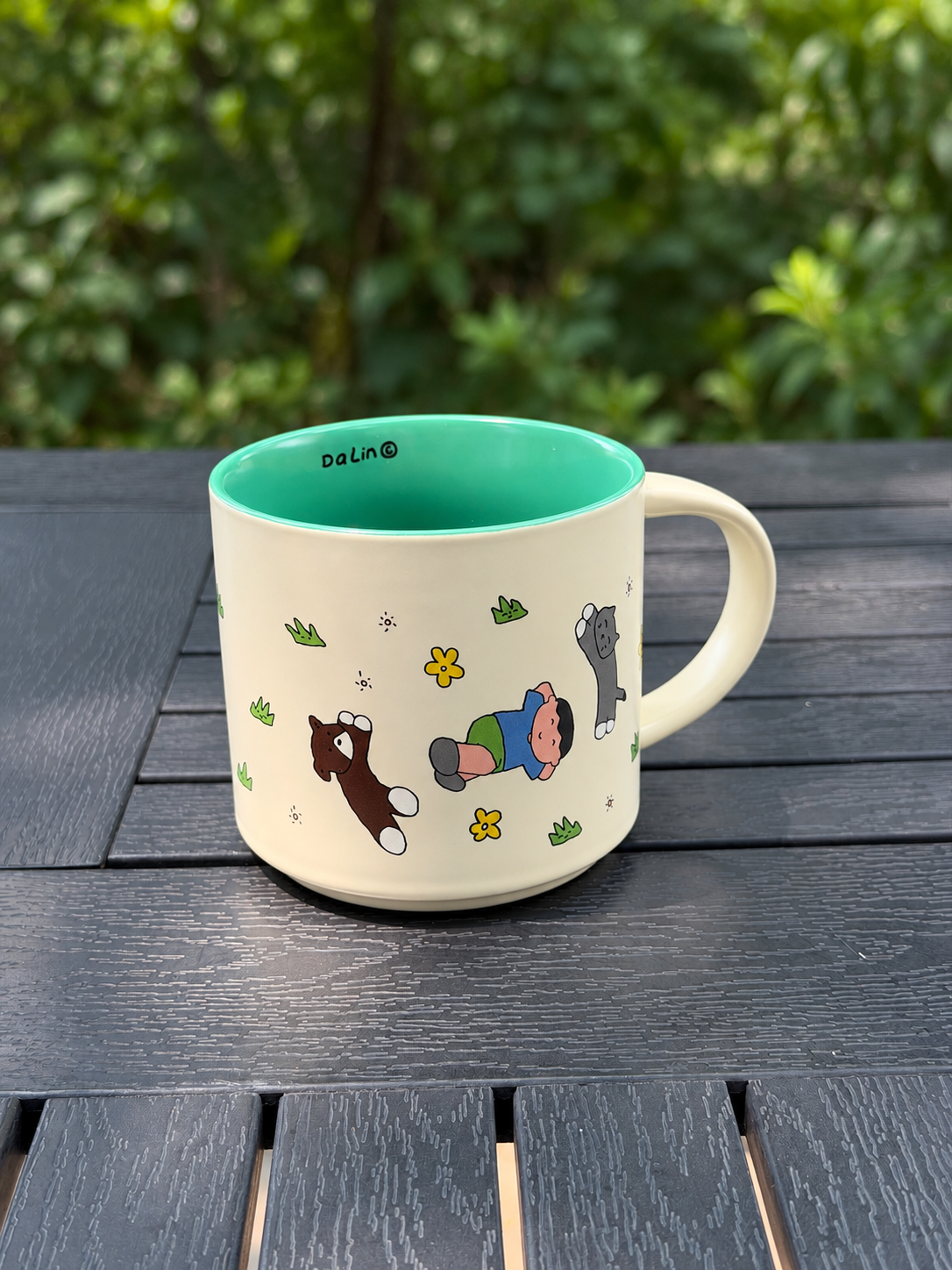 Angled view of the Mint Green mug showing the child and animal illustration, curved handle, and green interior.