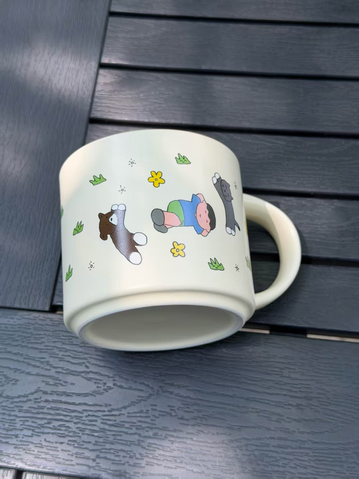 Warm Sand illustrated ceramic mug lying on its side, showing the exterior artwork and unglazed base.