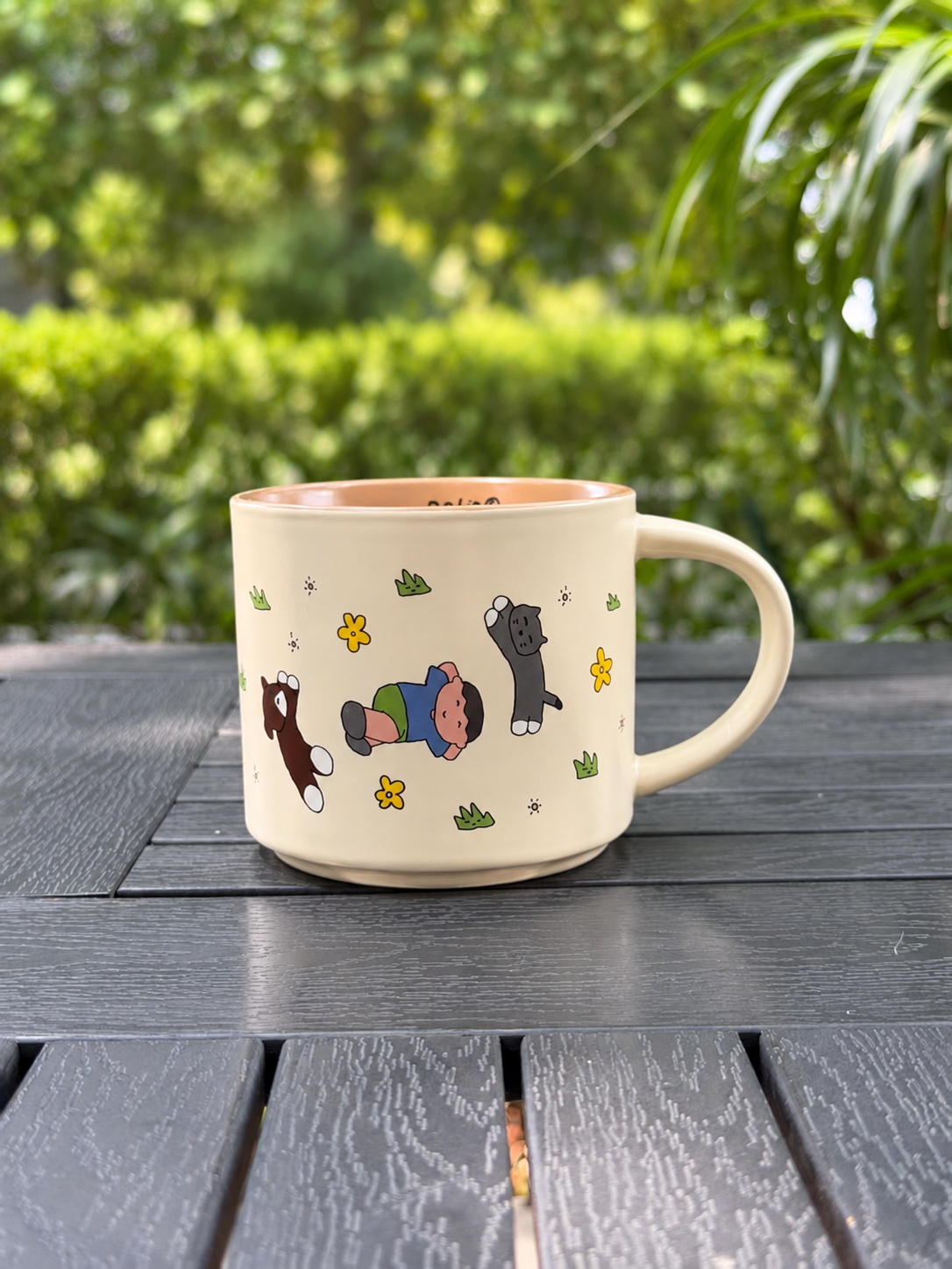 Warm Sand Orchard Companions ceramic mug with a child and animal illustration, shown with the handle on the right.