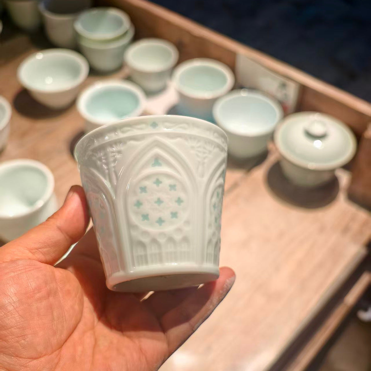 Front view of a hand-carved Linglong porcelain cup featuring architectural window motifs