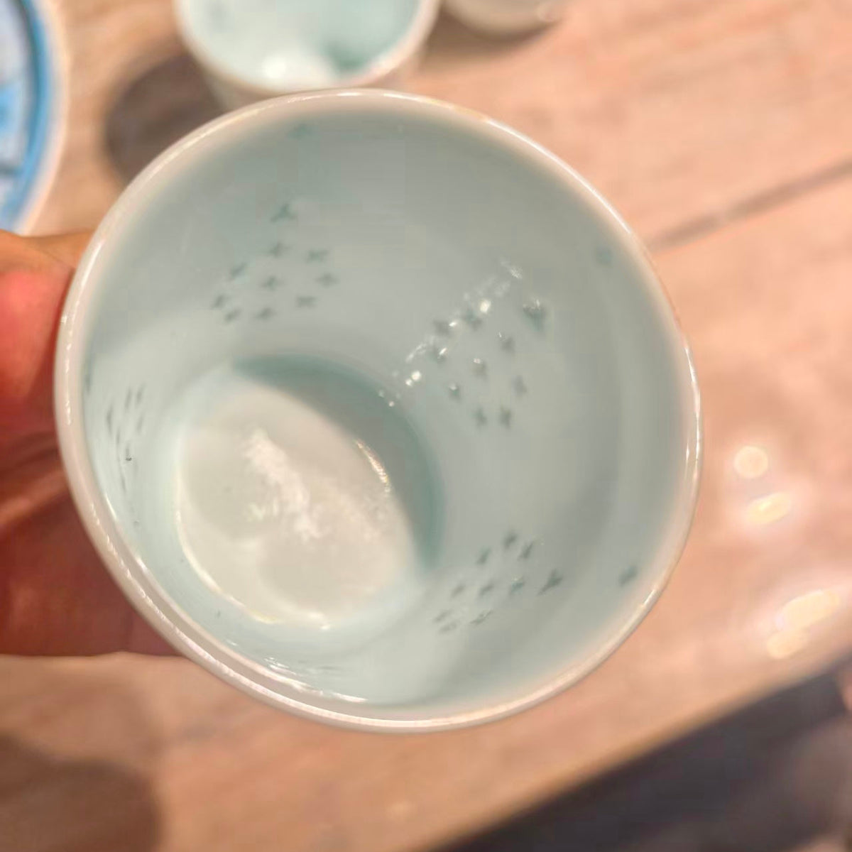 Top view of the Linglong porcelain cup showing its pale celadon interior and pierced details