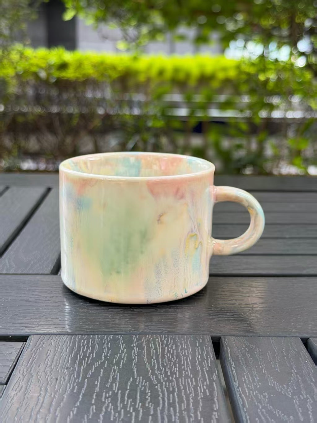 Pastel Meadow ceramic mug with soft green, blue, and blush reactive glaze, shown from the front with its handle on the right