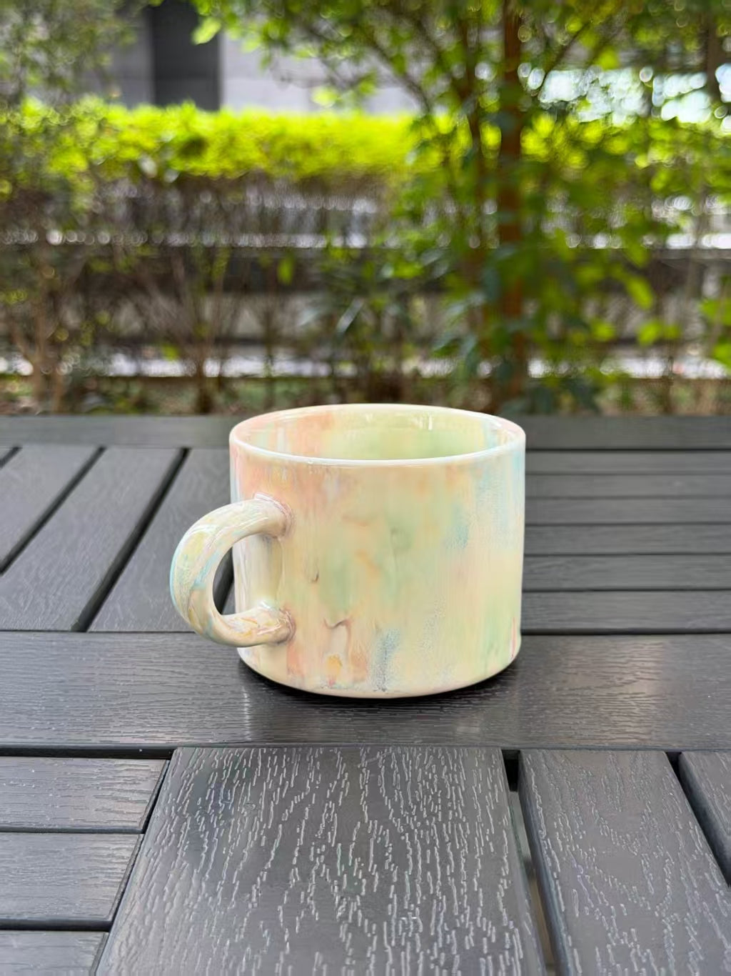 Side of the ceramic mug showing its curved handle and natural color variation around the glaze