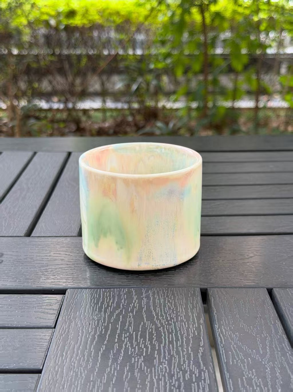 Opposite side of the Pastel Meadow mug showing flowing pastel glaze colors without the handle in view