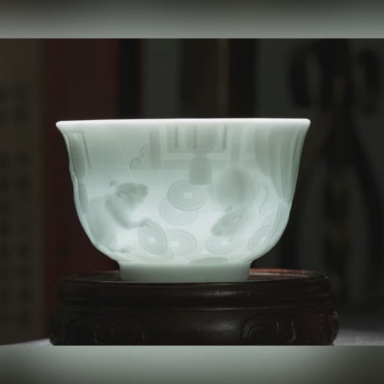 The Great Zodiac hand-carved porcelain tea cup by Jingdezhen artist Yan Wenlu, showing the detailed zodiac relief