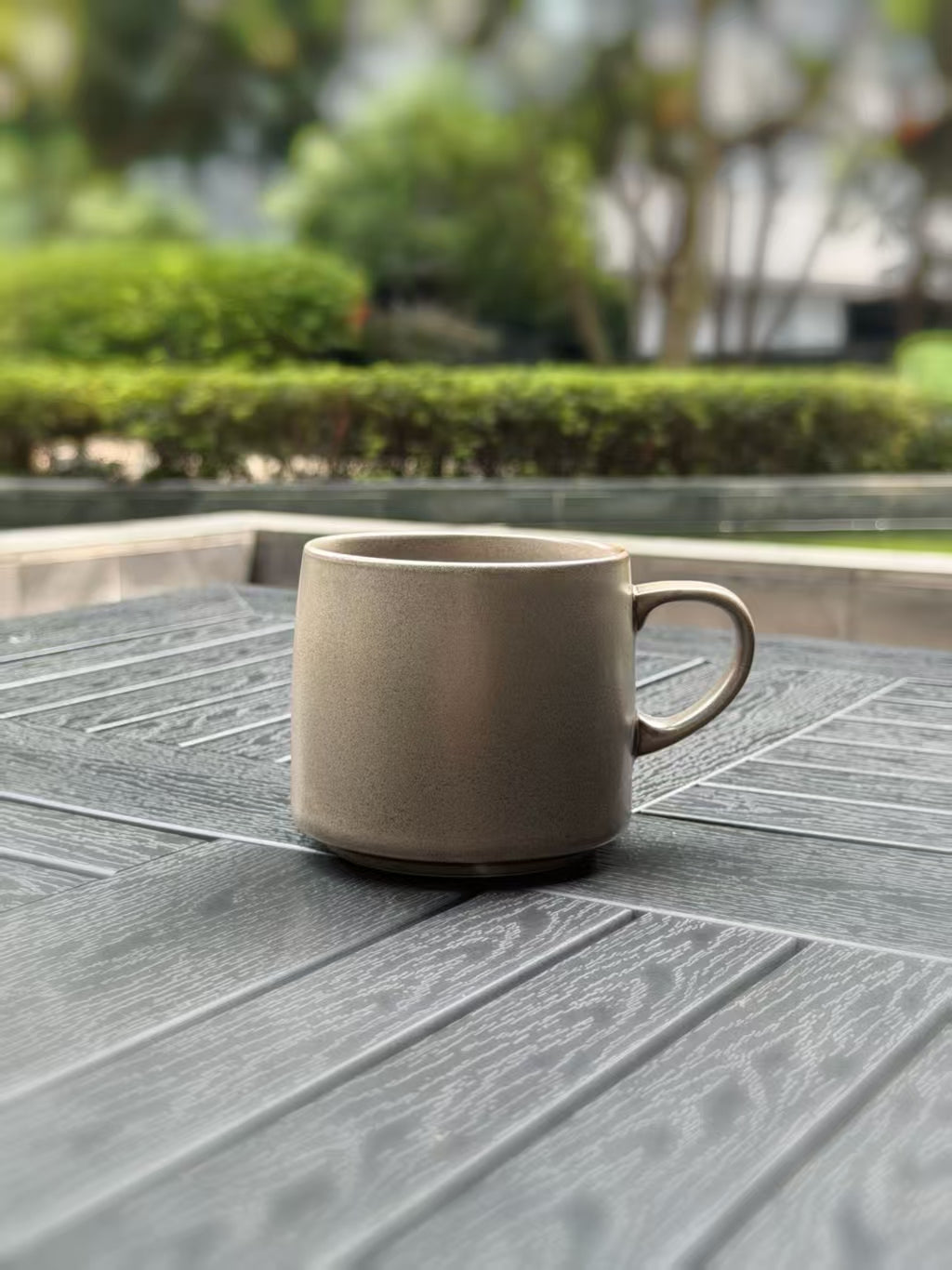 Front view of a large grey ceramic coffee mug with a rounded handle and natural textured finish