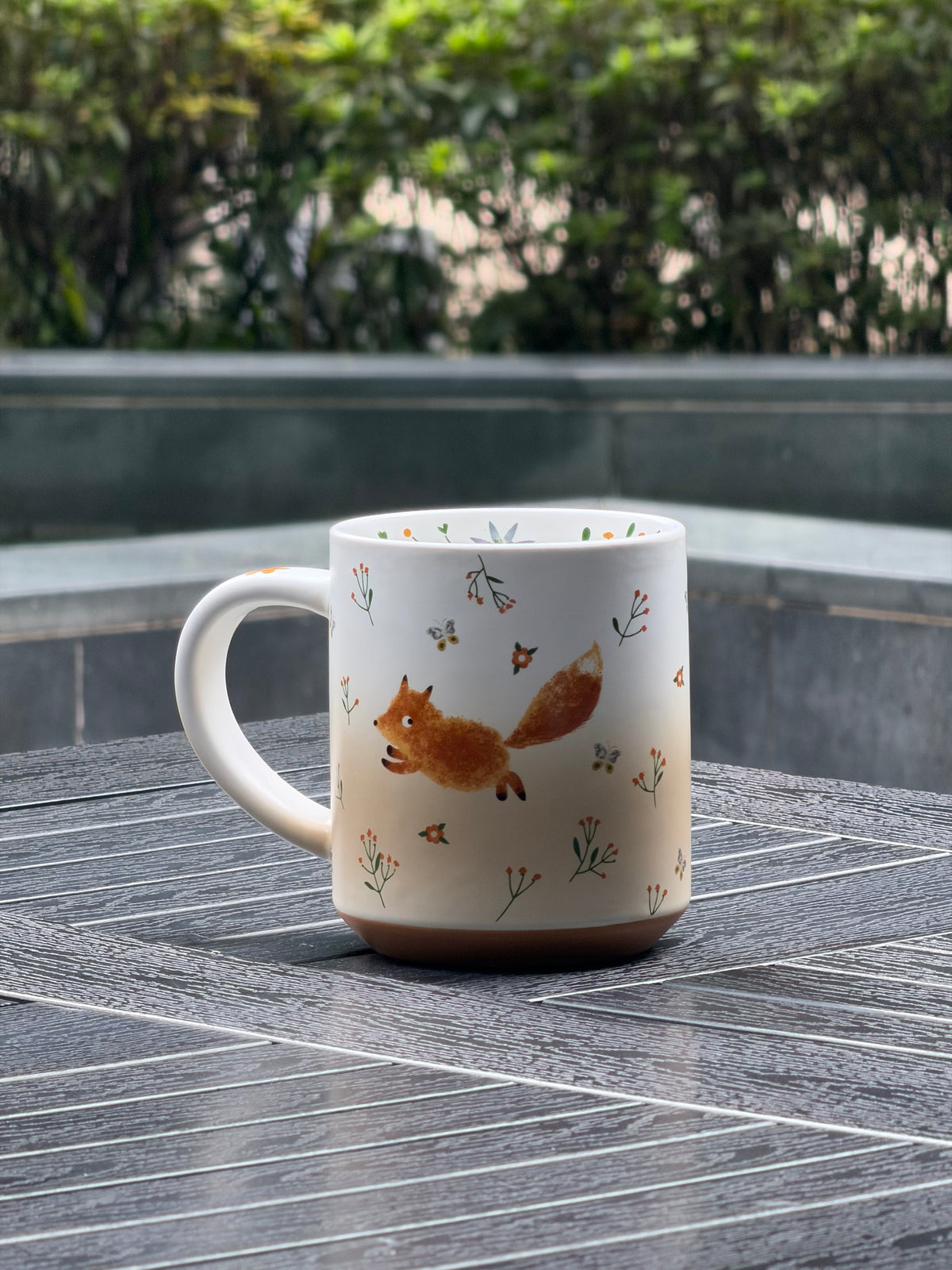 Side view of Running Fox ceramic mug showing the curved handle and warm ivory-to-brown gradient finish