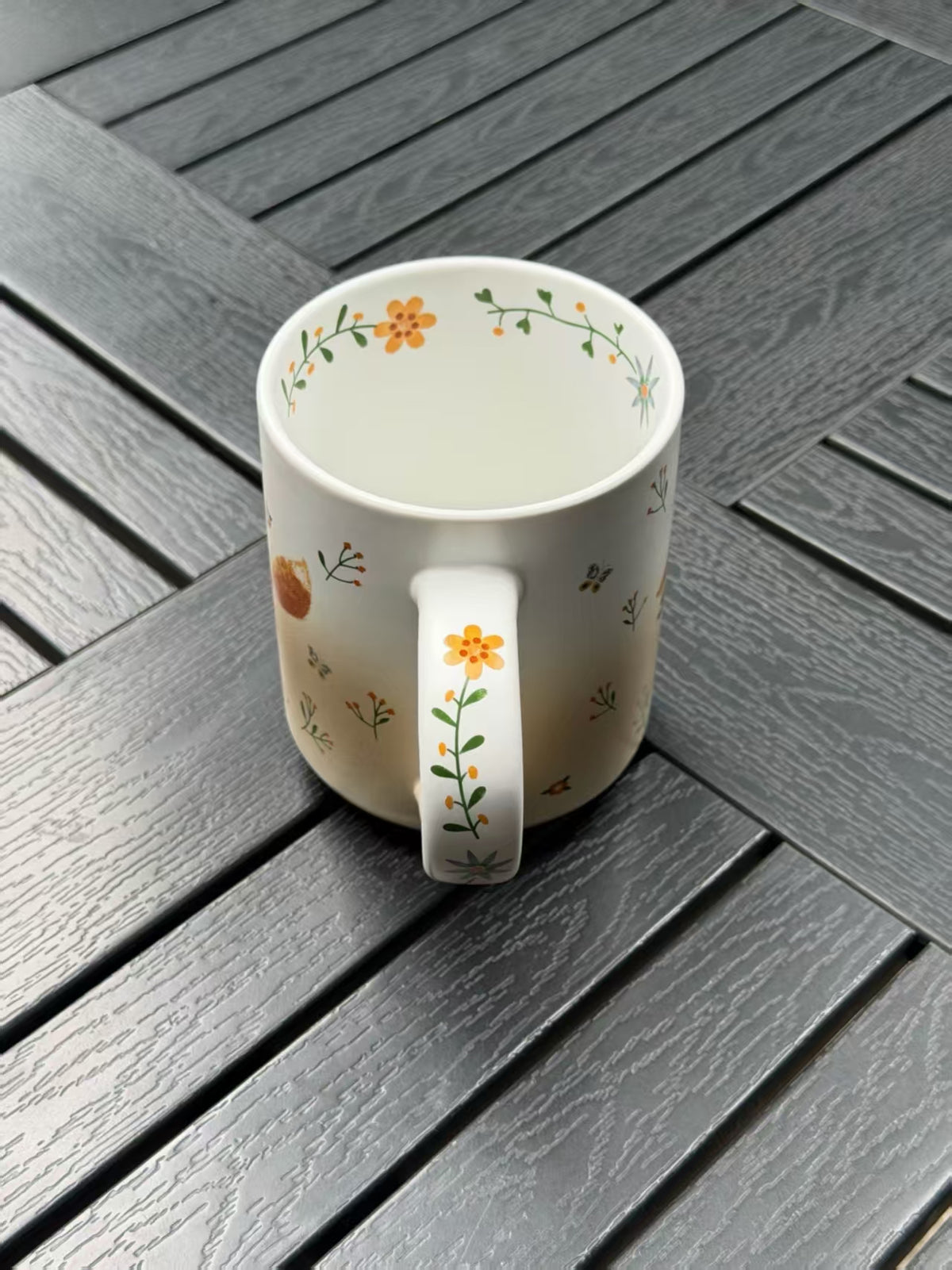 Inside of Running Fox ceramic mug with flowers and leafy decoration around the rim