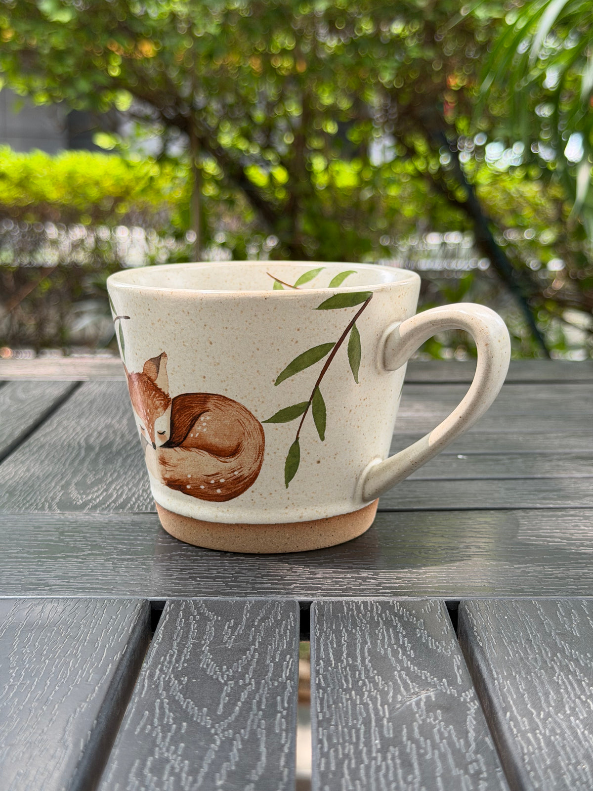 Opposite angled view showing the sleeping fox, green leaves and curved handle