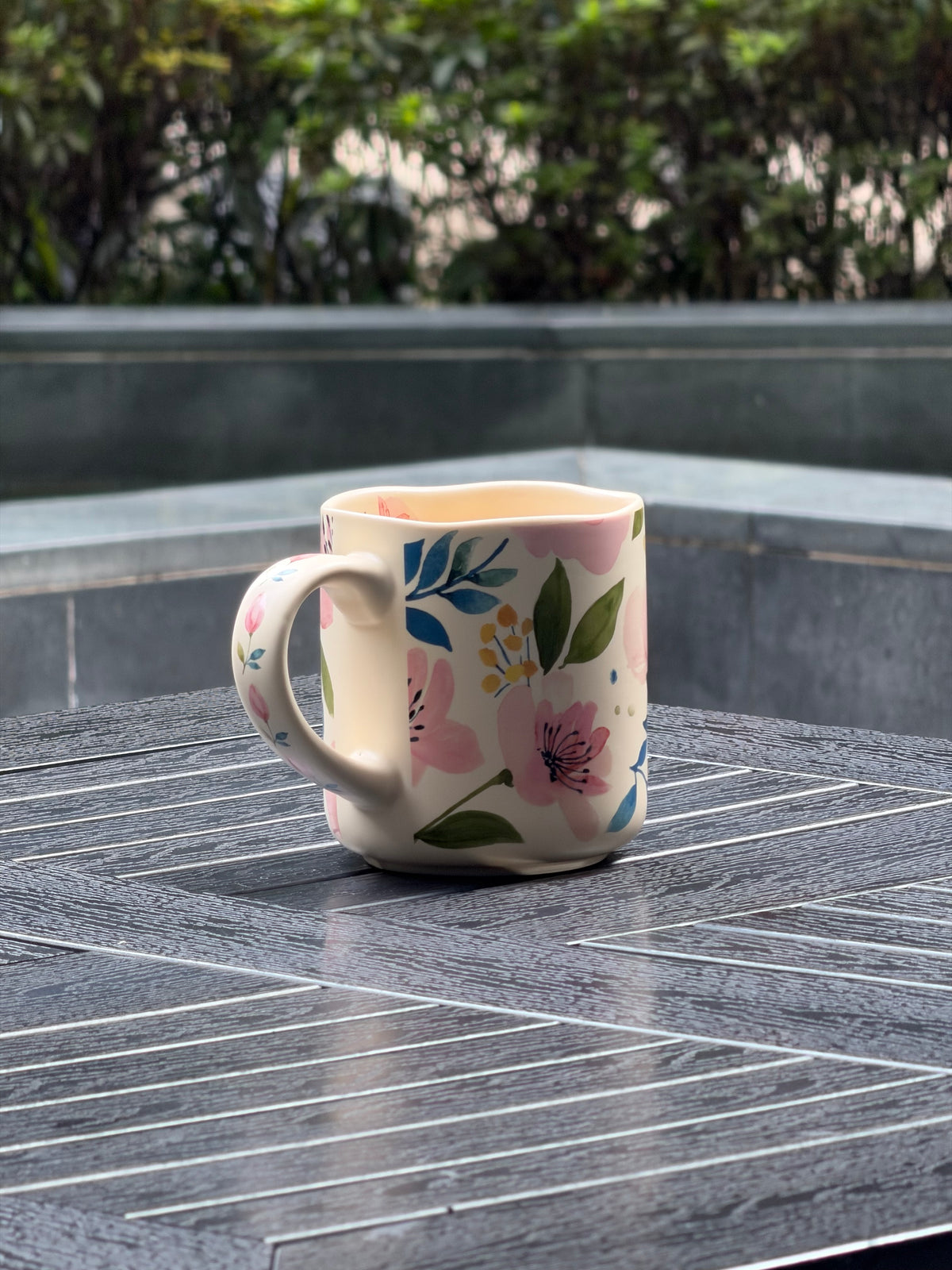 Curved ceramic mug handle decorated with delicate pink floral details