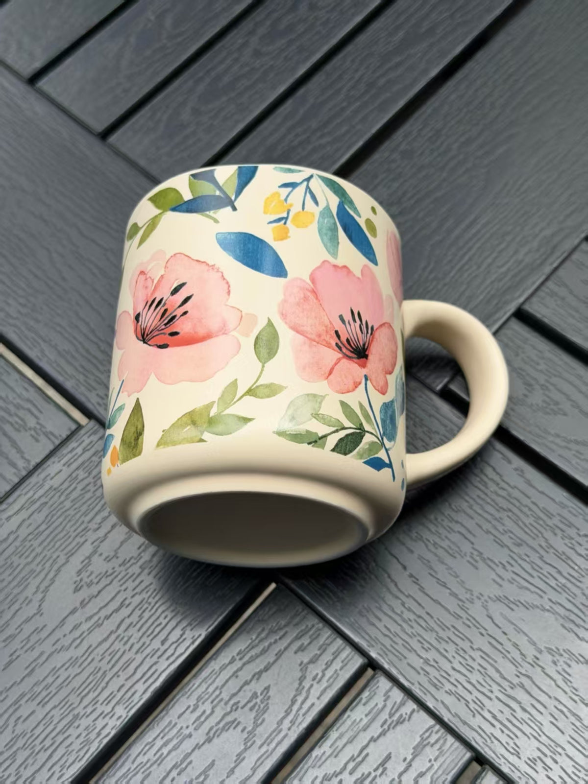 Close-up of pink floral and green leaf details on the matte ceramic surface of the Soft Bloom mug