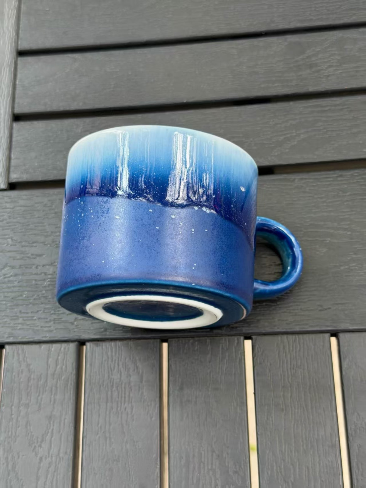 Mug resting on its side, showing the unglazed foot ring and blue glazed exterior
