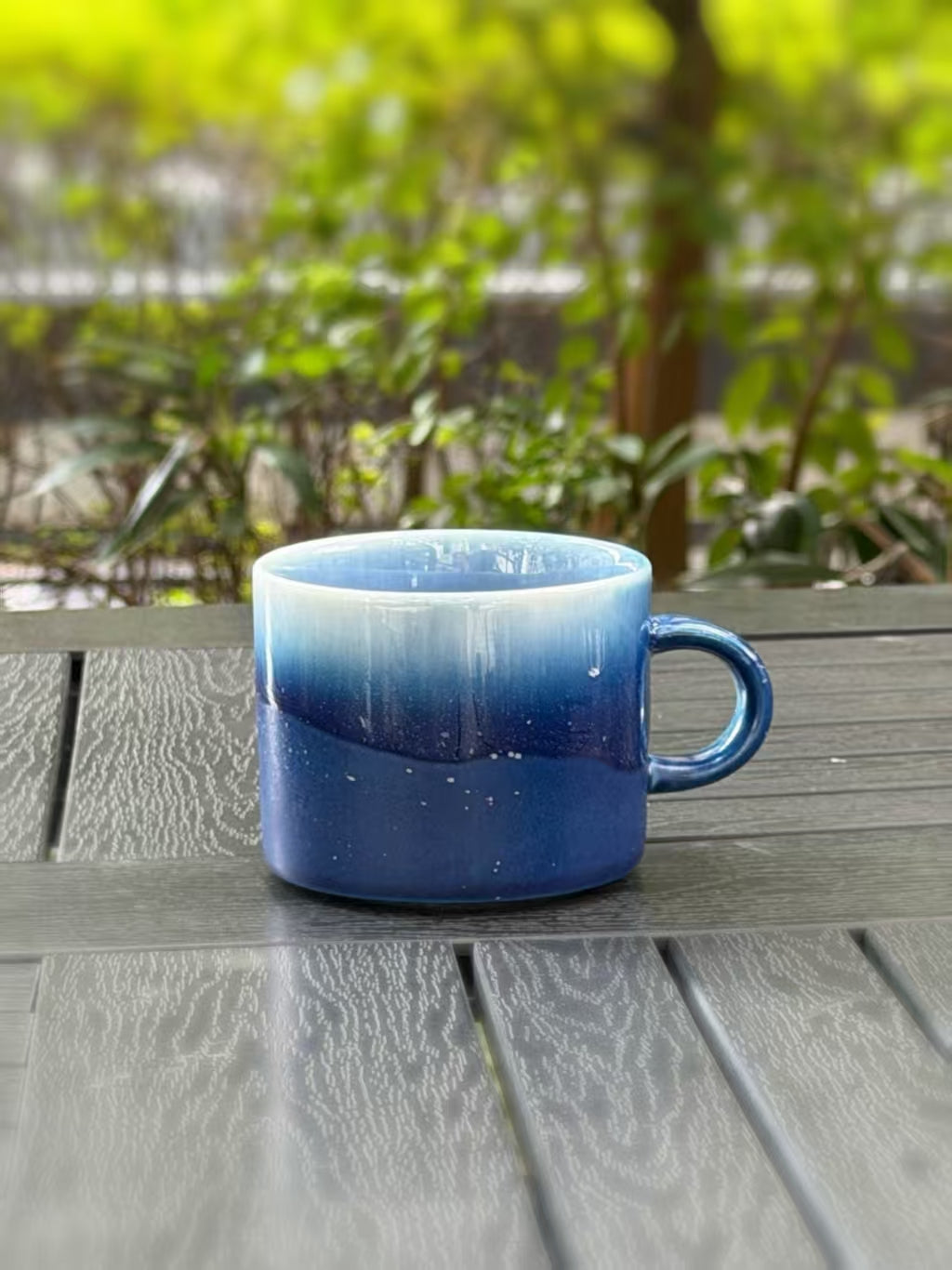 Starlit Sea ceramic mug showing its pale blue rim, deep blue glaze and curved handle