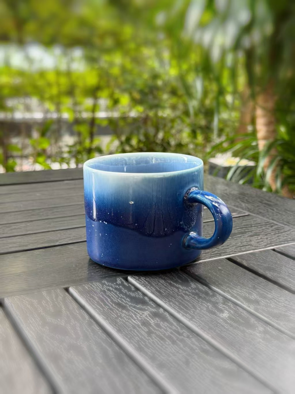 Side angle of the mug showing its handle and the blue kiln-glaze transition
