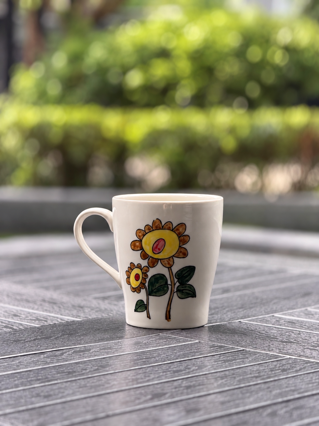 Back view of the Sunflower Muse hand-painted ceramic mug featuring two yellow sunflowers and green leaves.