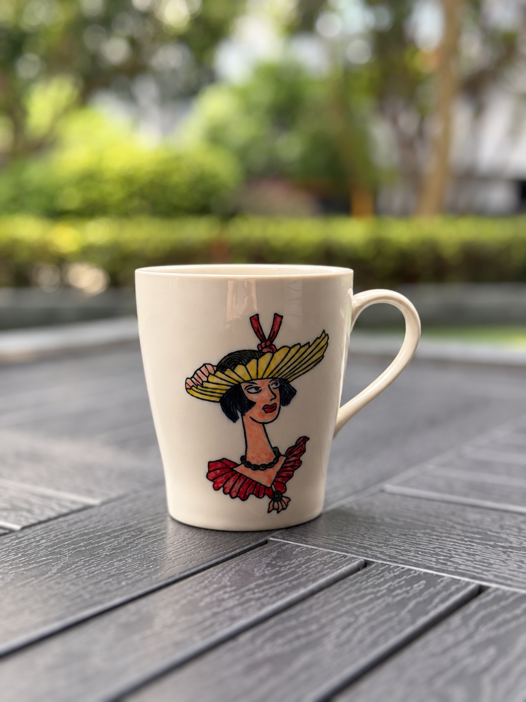 Front view of the Sunflower Muse hand-painted ceramic mug featuring a woman in a yellow sunflower hat and red dress.