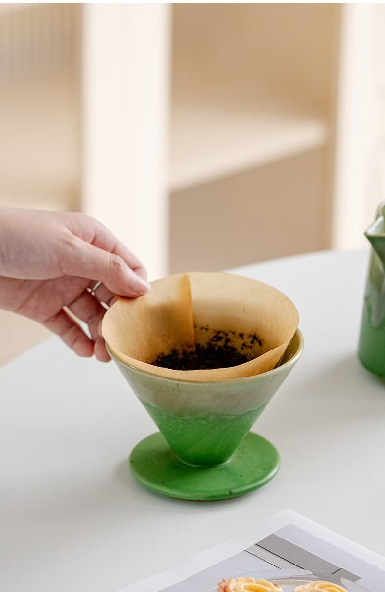 Green ceramic coffee dripper with filter detail close-up