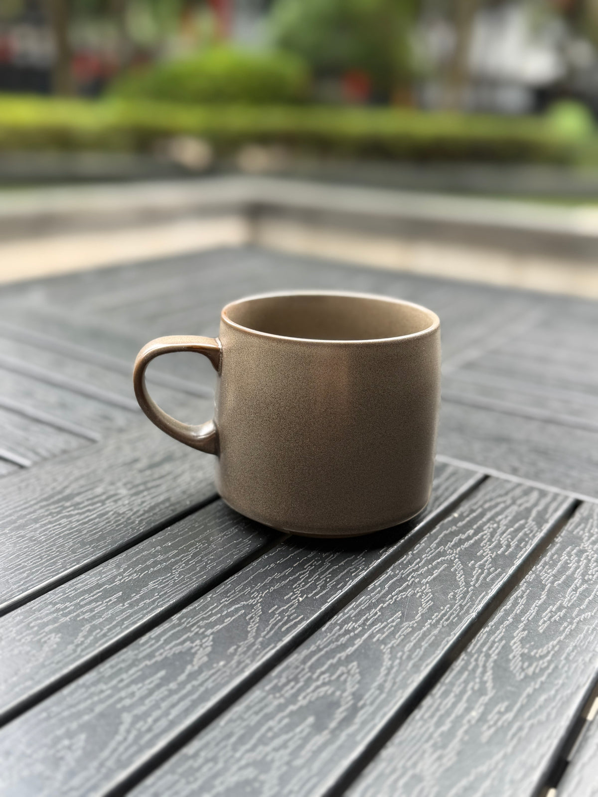 Closer back view of the Warm Stone ceramic mug showing its softly speckled grey glaze and curved handle