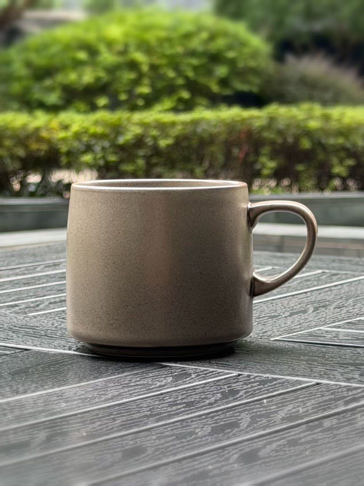 Close-up of a Warm Stone ceramic mug showing its subtly speckled grey glaze and rounded handle