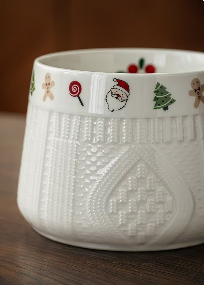 Close-up of raised knit texture and Christmas motifs on a white ceramic mug
