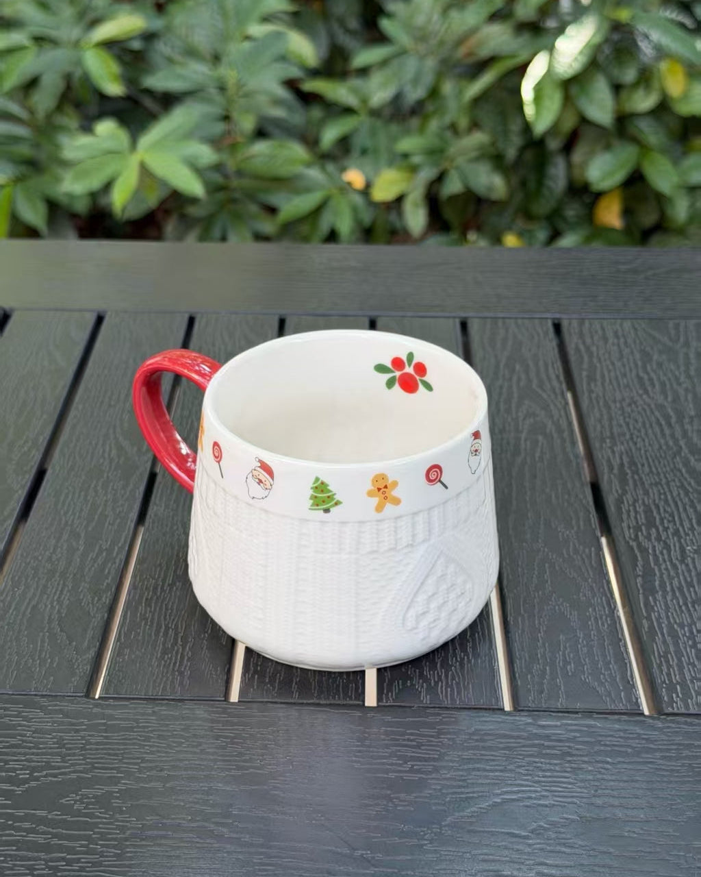 Side view of Winter Knit holiday ceramic mug with festive motifs and red handle