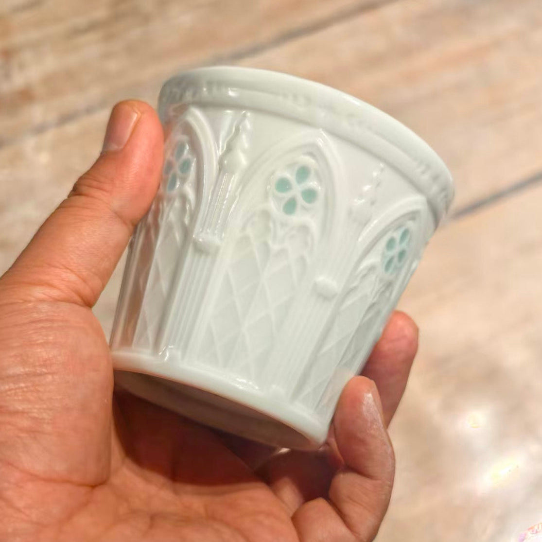 Hand-carved white Linglong porcelain cup with arched window patterns and pale celadon details