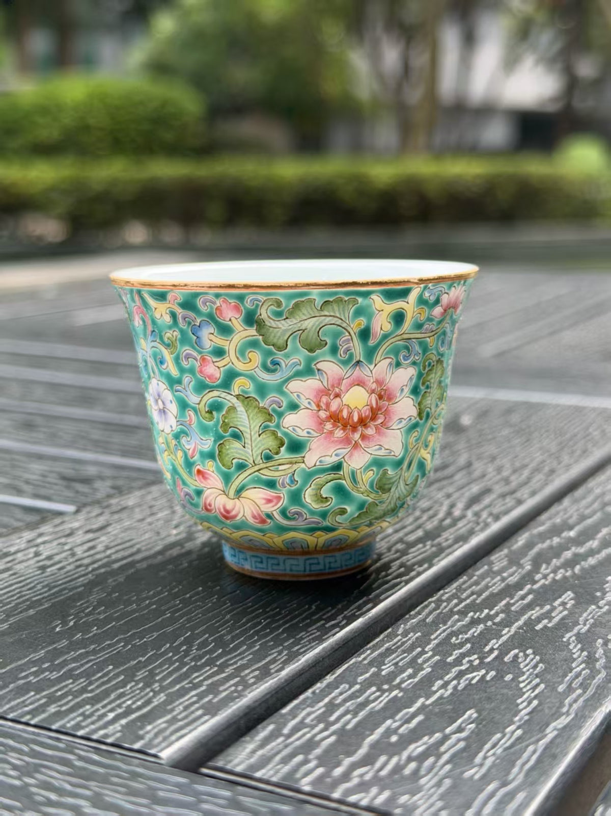 Closer view of the pink flower and detailed turquoise decoration on the porcelain teacup