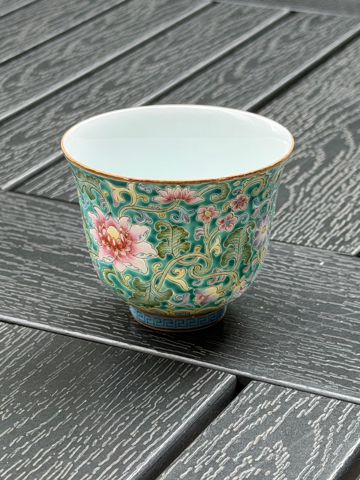 Angled view of Ying Shengxiang’s floral teacup showing the painted exterior and white interior